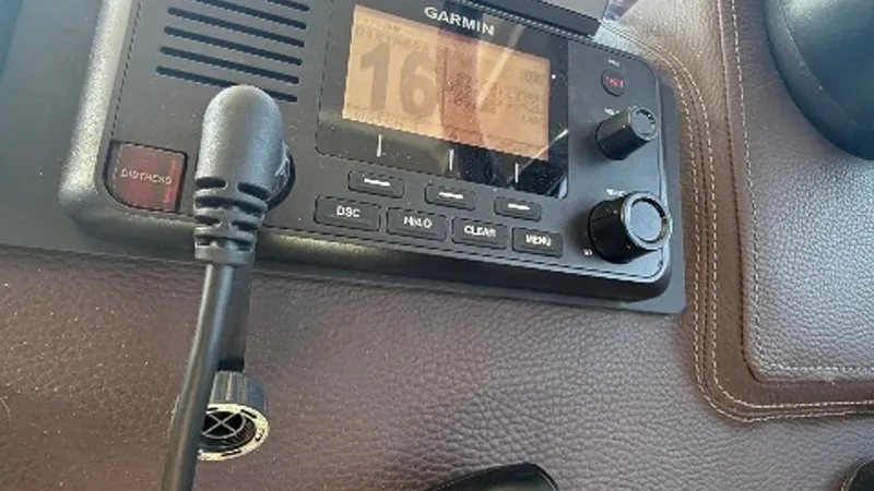 Slide: The Image of Helm Station Communication System Featured is the advanced Garmin communication system at the helm of the 2014 Regal 46 Sport Coupe, Serenity in the Sea. The sleek design integrates seamlessly into the leather-textured dashboard, offering easy access to essential controls. This setup ensu - 6857449