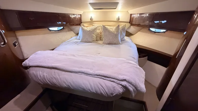 Slide: The Image of Luxurious Forward Stateroom The forward stateroom of the 2014 Regal 46 Sport Coupe exudes comfort with its plush double berth adorned with soft linens and pillows. Rich wood cabinetry and ambient lighting create a warm, inviting atmosphere, enhanced by natural light from the side po - 7162485