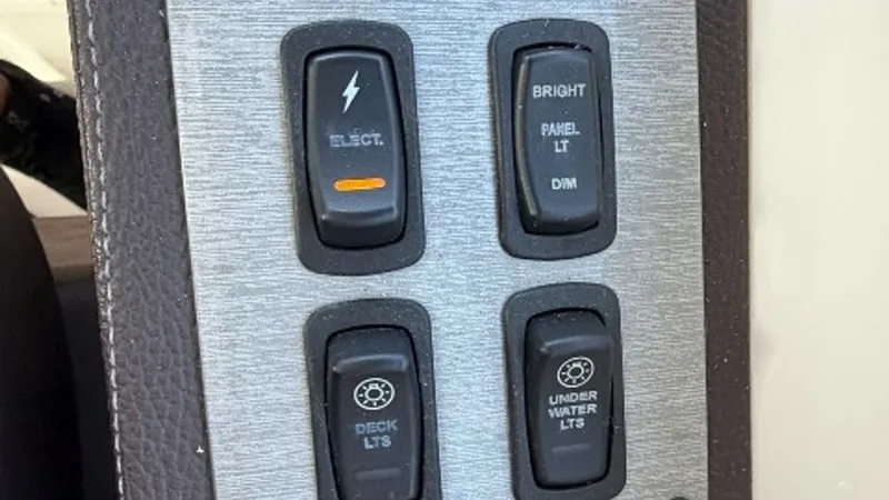 Slide: The Image of Control Panel for Lighting Systems This image showcases the control panel for the lighting systems on the 2014 Regal 46 Sport Coupe. The panel features switches for deck lights, underwater lights, and panel brightness, allowing for easy regulation of lighting throughout the vessel. The sle - 6857452
