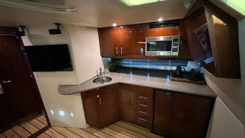 Slide: The Image of Galley with Modern Amenities This well-appointed galley in the 2014 Regal 46 Sport Coupe features sleek cabinetry and a polished countertop, offering ample space for meal preparation. Equipped with a built-in microwave and a compact sink, the area is designed for convenience and styl - 6857432