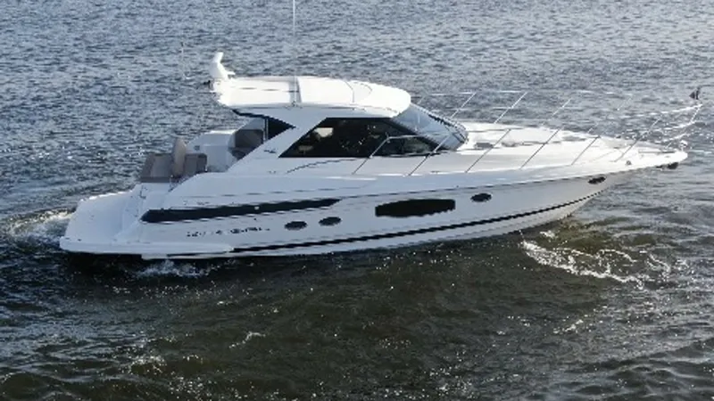 Slide: The Image of Starboard Side View of Cruiser This image showcases the sleek starboard profile of the 2014 Regal 46 Sport Coupe, highlighting its modern lines and expansive windows. The hardtop design offers both style and protection, while the spacious cockpit provides ample seating for leisure. Its - 6857487