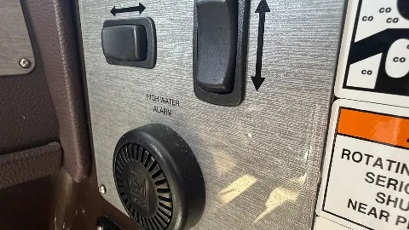 Slide: The Image of Control Panel with Safety Alerts This image showcases the control panel of the 2014 Regal 46 Sport Coupe, featuring essential switches and an audible high-water alarm. The sleek metallic finish complements the modern design, ensuring both functionality and style. Safety labels are clearl - 6857451