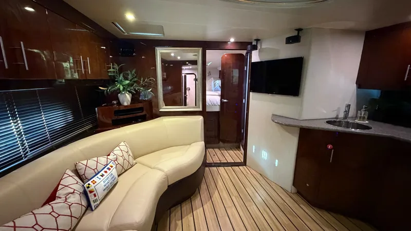 Slide: The Image of Luxury Interior Salon with Entertainment Center The interior salon of the 2014 Regal 46 Sport Coupe features elegant wood finishes and a plush curved sofa, providing a cozy and inviting atmosphere. The space is equipped with a modern entertainment center, complete with a flat-screen TV, perfect for rel - 6857426