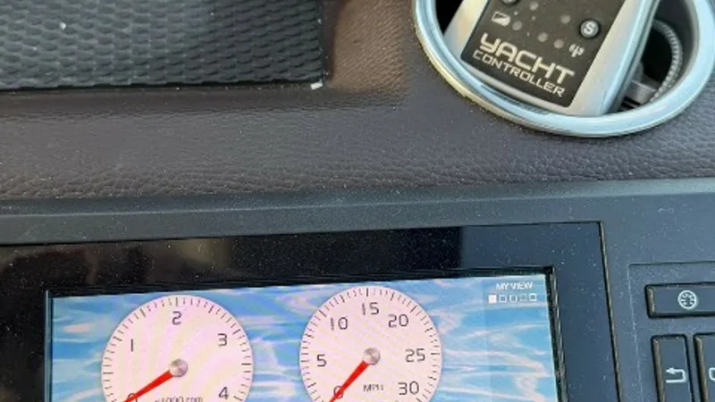 Slide: The Image of Helm Dashboard with Yacht Controller This image showcases the helm dashboard of the Regal 46 Sport Coupe, featuring a state-of-the-art display for engine speed and boat speed. The inclusion of a yacht controller highlights the vessel's advanced technological capabilities, offering precise na - 6857445