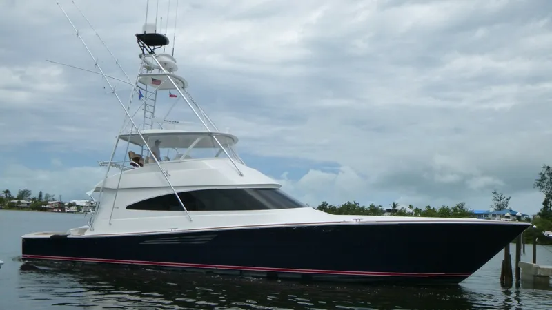 Slide: The Image of Starboard Profile of Viking 68 Convertible This image showcases the sleek starboard profile of the 2022 Viking 68 Convertible, highlighting its elegant lines and powerful stance. The vessel features a striking dark hull with a contrasting white superstructure, complemented by a spacious flybridge - 6862371