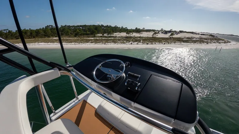 Slide: The Image of Flybridge Helm Station View The flybridge helm station of the 2022 Viking 68 Convertible offers a commanding view with its sleek design and modern instrumentation. The ergonomic steering wheel and well-placed controls ensure an intuitive piloting experience. The surrounding cushione - 7463791