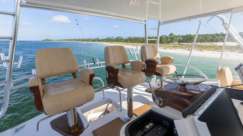 Slide: The Image of Flybridge with Captain's Chairs The flybridge of the 2022 Viking 68 Convertible offers an expansive view with luxurious captain's chairs, providing ultimate comfort for navigating. The helm is equipped with state-of-the-art controls, ensuring precise handling and ease of operation. Larg - 7463823