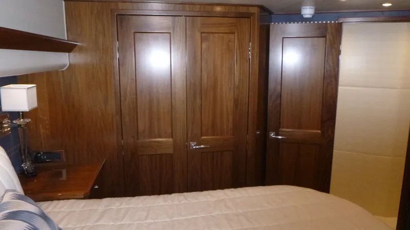 Slide: The Image of Master Stateroom The elegant master stateroom features rich wood finishes and sleek, modern design. The room is equipped with ample storage options, including beautifully crafted wooden cabinets and doors. Soft, ambient lighting creates a warm and inviting atmosphere, per - 6862338