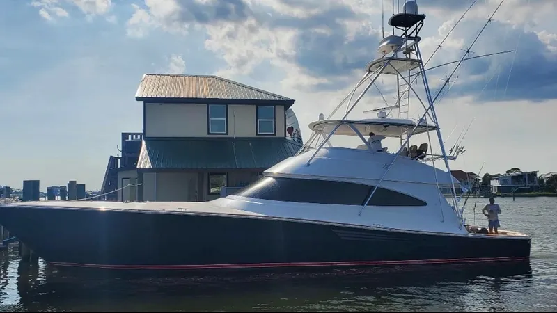 Slide: The Image of Side Profile of Viking 68 Convertible This image showcases the sleek side profile of the 2022 Viking 68 Convertible, 'Tax Man'. The yacht's elegant lines and aerodynamic design are complemented by a robust tower, offering excellent visibility for sportfishing. The dark hull contrasts beautifu - 6862369
