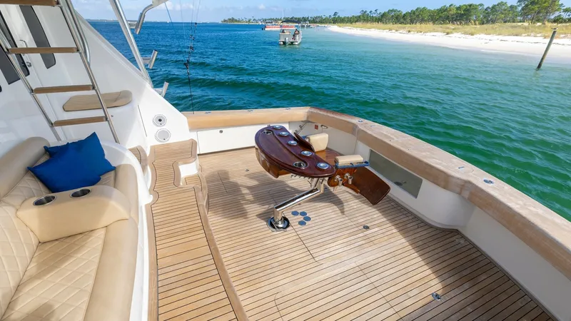 Slide: The Image of Spacious Aft Deck with Teak Flooring The aft deck of the 2022 Viking 68 Convertible, 'Tax Man,' features elegant teak flooring and a robust fighting chair, ideal for serious fishing enthusiasts. The plush seating with a pop of color from the blue cushion offers a comfortable spot to relax an - 7463796