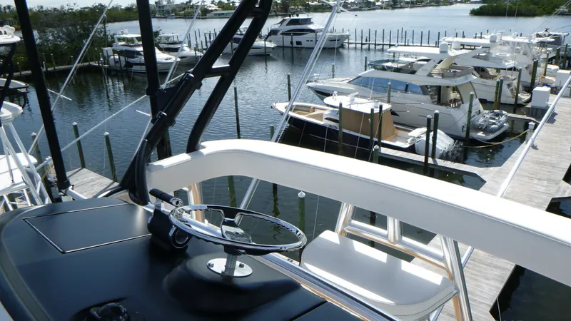 Slide: The Image of Tower Helm Station The tower helm station of the 2022 Viking 68 Convertible offers a commanding view of the marina. Featuring a sleek, modern design, the helm is equipped with a state-of-the-art steering wheel and intuitive controls for ease of navigation. The spacious layo - 6862360