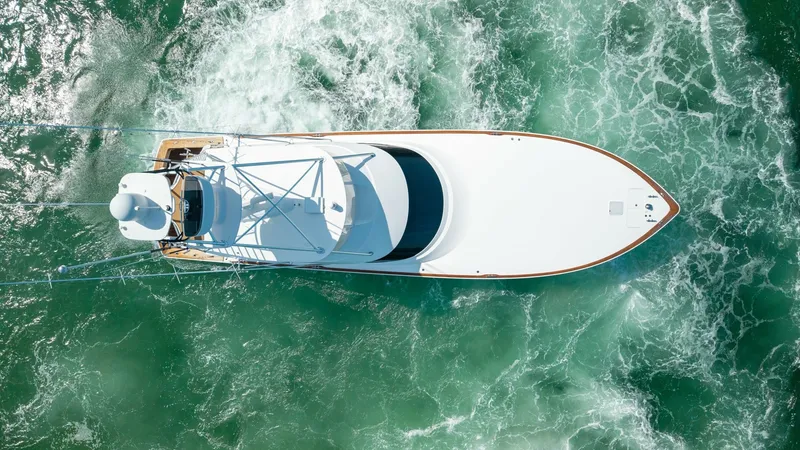 Slide: The Image of Aerial View of Viking 68 Convertible This stunning aerial shot captures the sleek design and dynamic presence of the 2022 Viking 68 Convertible. The streamlined hull and expansive deck layout are highlighted against the vibrant, swirling ocean below. This vessel exemplifies luxury and perfor - 7463838