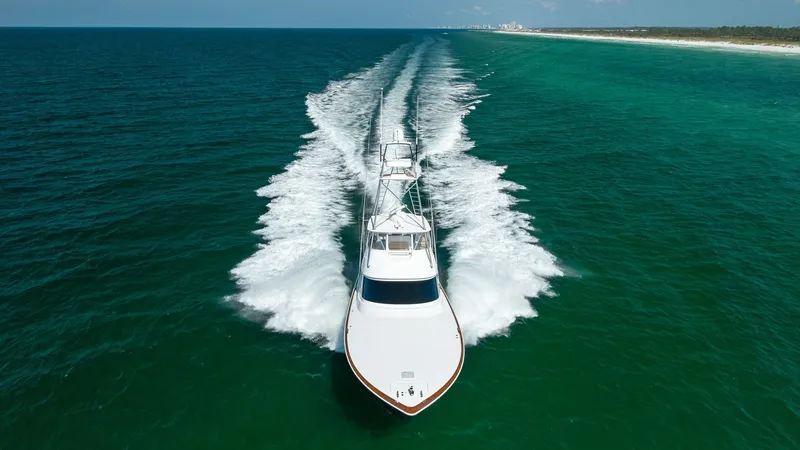 Slide: The Image of Aerial View of Bow and Wake This image captures an impressive aerial view of the Viking 68 Convertible, named Tax Man, slicing through the water with precision. The sleek bow design showcases the vessel's aerodynamic efficiency and superior build quality. The expansive wake trailing - 7463836