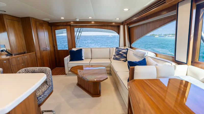 Slide: The Image of Spacious Salon with Panoramic Views The salon of the 2022 Viking 68 Convertible 'Tax Man' offers a blend of luxury and comfort, featuring plush L-shaped seating and elegant wood finishes. Large windows provide panoramic ocean views, enhancing the open and airy atmosphere. The sophisticated - 7463800