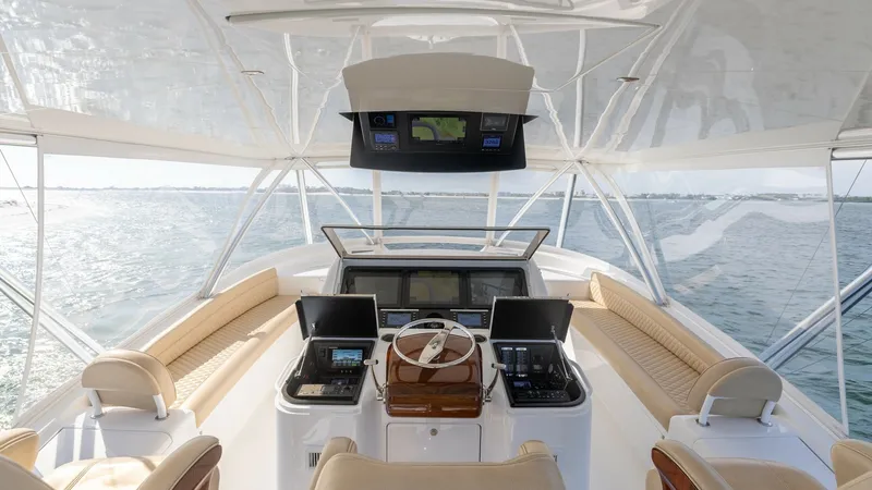 Slide: The Image of Flybridge Helm with Dual Seating The flybridge helm of the 2022 Viking 68 Convertible offers a commanding view with state-of-the-art navigation displays and controls. The spacious layout includes plush seating for captain and guests, finished with elegant wooden accents. The surrounding - 7463790