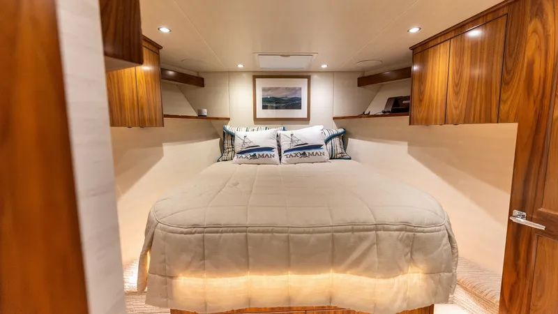 Slide: The Image of Luxurious Forward Stateroom This inviting forward stateroom on the 2022 Viking 68 Convertible offers elegance and comfort. The space features rich wood cabinetry, ambient recessed lighting, and plush bedding for a restful retreat. Thoughtfully designed storage and a serene atmospher - 7463812