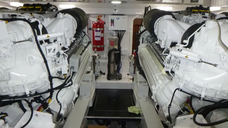 Slide: The Image of Engine Room with Twin Engines The engine room of the Viking 68 Convertible features powerful twin engines, meticulously maintained for optimal performance. The space is well-organized and clean, with easy access for maintenance and operations. Notable elements include the advanced fir - 6862364