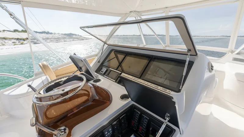 Slide: The Image of Flybridge Helm Station The flybridge helm station of the 2022 Viking 68 Convertible offers a sleek and modern control area. Featuring state-of-the-art navigation displays and a polished wooden steering wheel, this space is designed for both functionality and style. The panorami - 7463824
