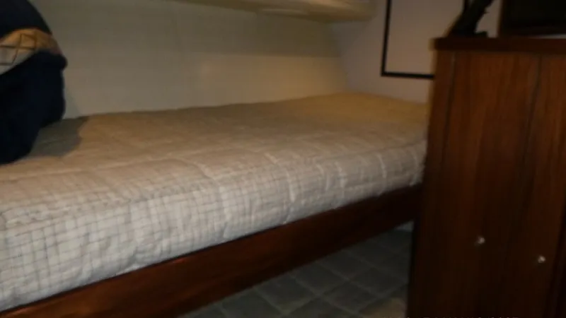 Slide: The Image of Port Stateroom The port guest stateroom features comfortable bunk berths with elegant wood accents. The soft lighting and neutral tones create a welcoming atmosphere, ideal for relaxation. Ample storage is available in the adjacent cabinetry, providing convenience for e - 6862347