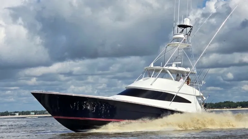Slide: The Image of Viking 68 Convertible in Motion The 2022 Viking 68 Convertible, named 'Tax Man', showcases its sleek, dynamic profile cutting through the water with precision. The vessel's robust hull and elegant design are complemented by a towering flybridge, equipped with the latest navigational tec - 6862372