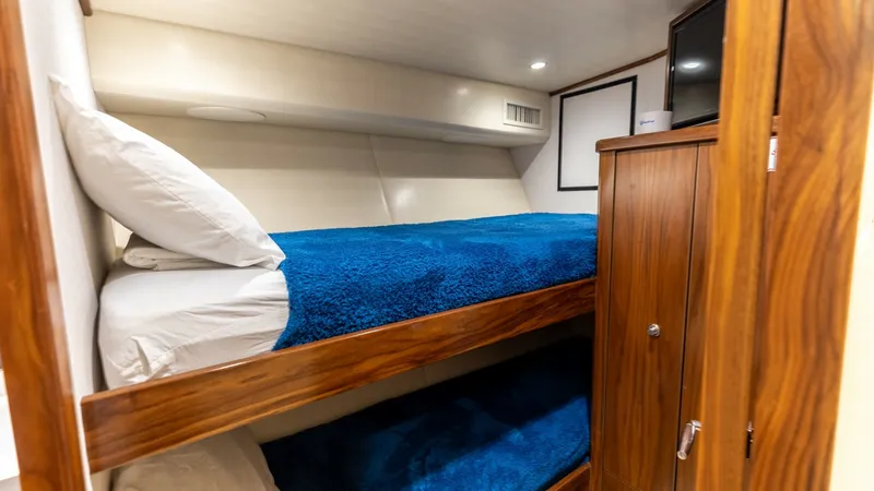 Slide: The Image of Guest Cabin with Bunk Beds This cozy guest cabin features twin bunk beds, perfect for accommodating additional guests in comfort. The rich wood cabinetry adds a touch of elegance, while the soft recessed lighting creates a warm and inviting atmosphere. Ample storage space ensures a - 7463816