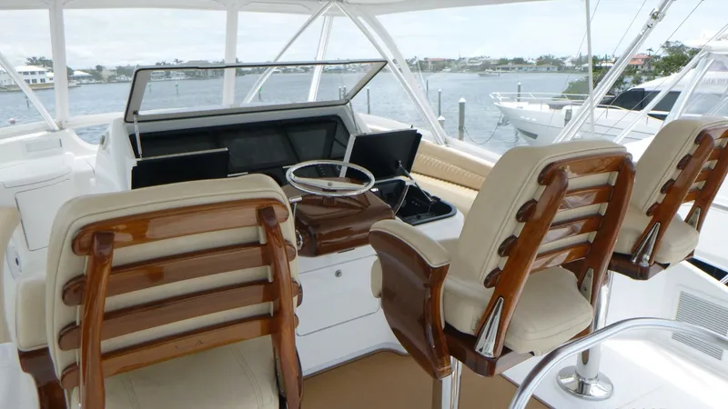 Slide: The Image of Flybridge Helm The flybridge helm of the 2022 Viking 68 Convertible offers a commanding view with state-of-the-art navigation equipment. Luxurious teak captain's chairs provide comfort and style, complemented by a sleek console with ample displays. The panoramic windows - 6862326
