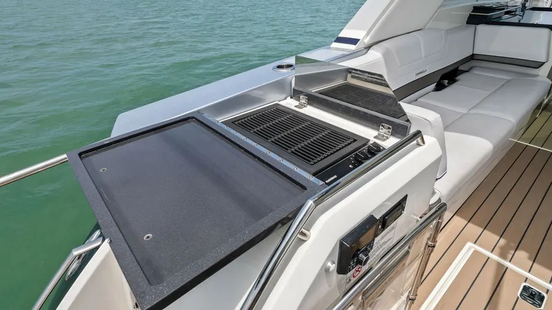 Slide: The Image of Outdoor Galley with Grill and Seating This image showcases the sleek outdoor galley of the 2022 Formula 430 Super Sport Crossover. Featuring a built-in grill and ample countertop space, it's perfect for alfresco dining and entertaining. Adjacent to the galley is a comfortable seating area wit - 7030608
