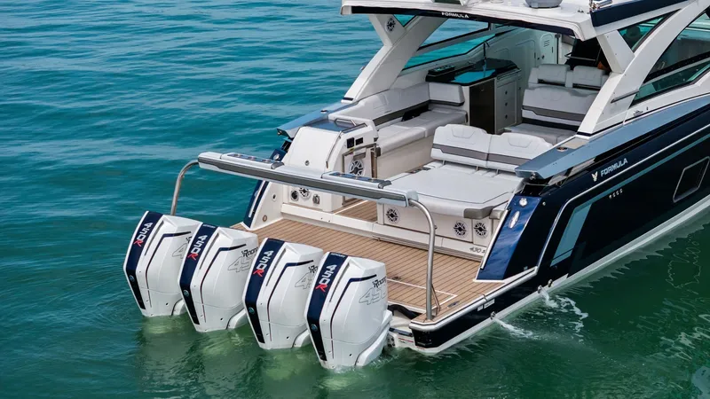 Slide: The Image of Stern with Quad Outboard Engines The stern of the 2022 Formula 430 Super Sport Crossover, 'Blue Agave,' showcases four powerful outboard engines, emphasizing its performance capabilities. The teak swim platform provides easy access to the water, while the spacious cockpit features sleek, - 7030644