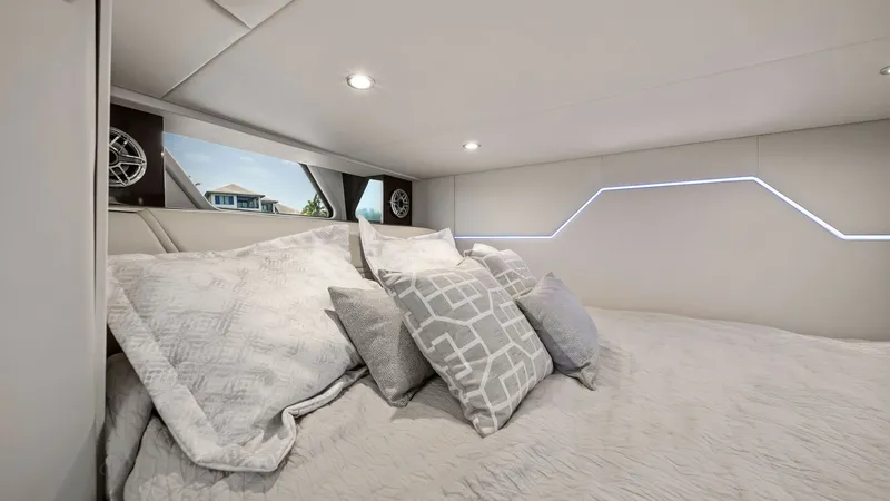 Slide: The Image of Luxurious Cabin with Plush Bedding This inviting cabin on the 2022 Formula 430 Super Sport Crossover features a spacious bed adorned with plush pillows and a luxurious quilt. The modern design is complemented by sleek, soft lighting and contemporary wall accents. Large windows offer natura - 7030628