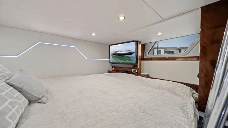 Slide: The Image of Master Stateroom with Modern Accents The master stateroom of the 2022 Formula 430 Super Sport Crossover features a spacious berth with luxurious bedding. Modern LED accent lighting and polished wood finishes create an inviting and contemporary ambiance. A large window and integrated entertai - 7030627