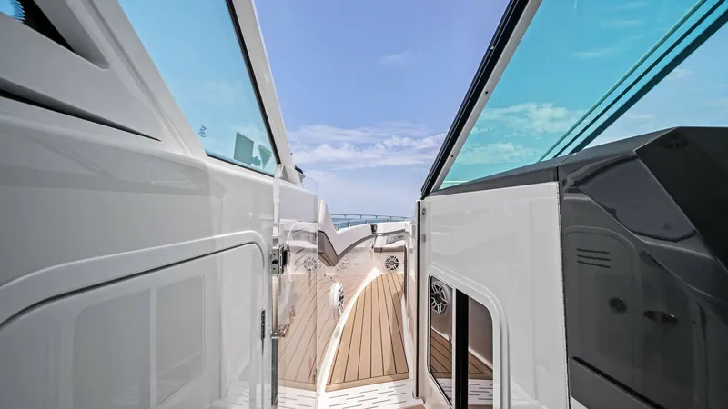Slide: The Image of Portside Walkway with Teak Decking The image showcases the sleek portside walkway of the 2022 Formula 430 Super Sport Crossover, featuring elegant teak decking. The clear, protective glass panels provide an unobstructed view of the surrounding waters, enhancing the open-air experience. Thi - 7030617