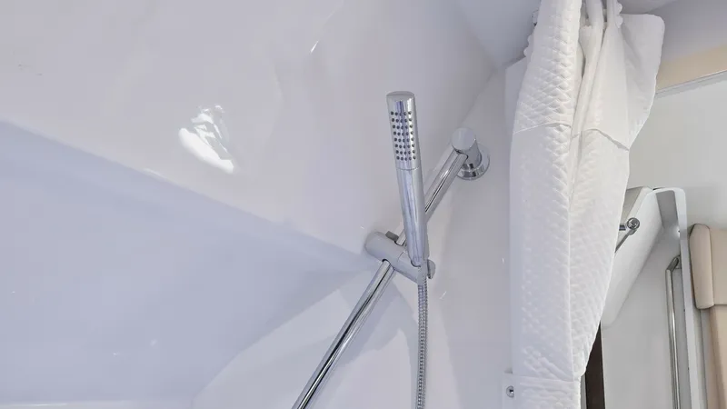Slide: The Image of Shower Area with Chrome Fixtures The shower area of the 2022 Formula 430 Super Sport Crossover, Blue Agave, features sleek chrome fixtures and a modern design. The pristine white walls enhance the clean and spacious feel, while the adjustable showerhead offers convenience and flexibility - 7030626