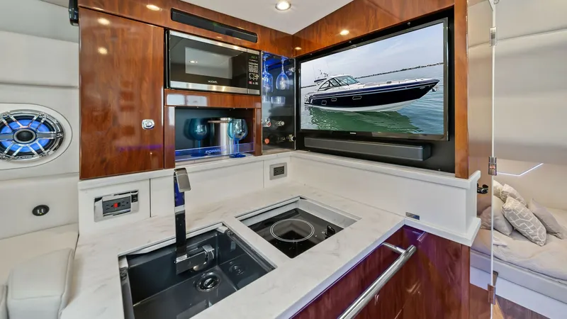 Slide: The Image of Gourmet Galley with Entertainment System The galley of the 2022 Formula 430 Super Sport Crossover features a sleek, modern design with polished wood cabinetry and a pristine marble countertop. Equipped with state-of-the-art appliances, including a built-in microwave and dual sink, it offers both - 7030623