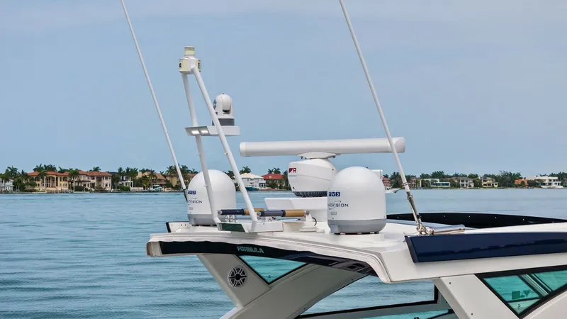 Slide: The Image of Advanced Navigation and Radar Systems This image showcases the sophisticated navigation and radar systems atop the Formula 430 Super Sport Crossover. Featuring cutting-edge radar domes and antennas, the setup ensures optimal communication and safety on the water. The sleek design integrates s - 7030641