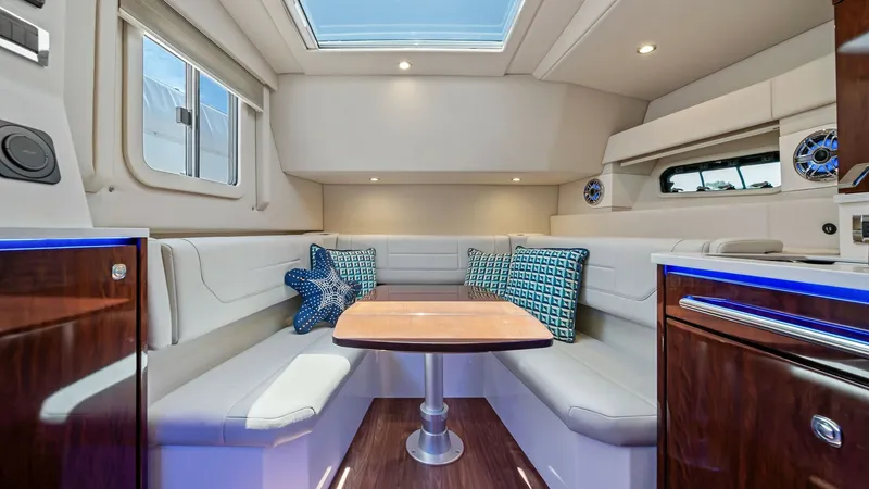 Slide: The Image of Spacious Interior Dining Area The interior dining area of the 2022 Formula 430 Super Sport Crossover features plush U-shaped seating with elegant, modern upholstery. A skylight overhead provides natural illumination, enhancing the warm ambiance created by the wooden finishes and accen - 7030622