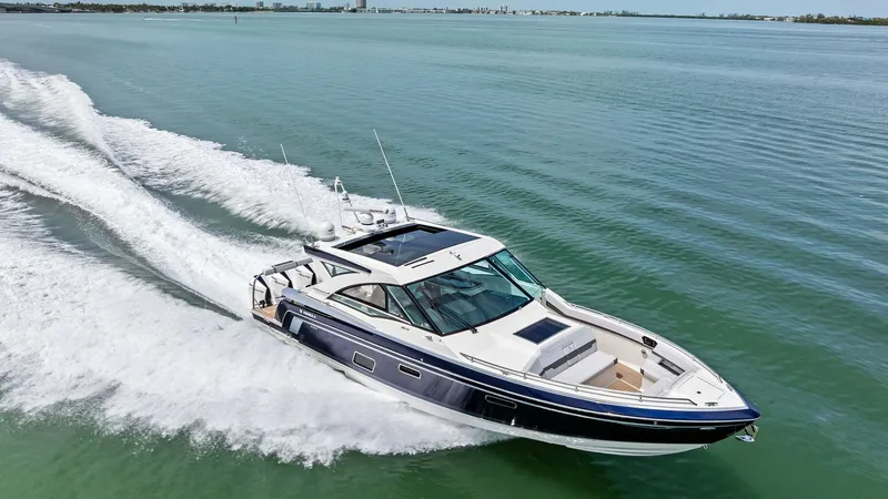 Slide: The Image of Aerial View of Bow and Cabin The Formula 430 Super Sport Crossover 'Blue Agave' showcases its sleek design as it glides effortlessly over the water. The bow area is expansive, featuring ample seating and a stylish rail for safety. The cabin's streamlined architecture and large window - 7030635