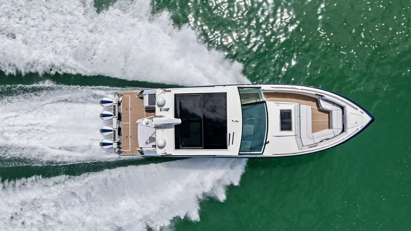 Slide: The Image of Aerial View of Sporty Deck The 2022 Blue Agave by Formula, a 430 Super Sport Crossover, is captured from above showcasing its sleek design and powerful outboard engines. The spacious aft deck features ample seating and sunbathing areas, perfect for leisure and entertainment. The ve - 7030636