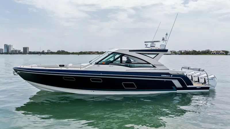 Slide: The Image of Side Profile of Formula 430 SSC The 2022 Formula 430 Super Sport Crossover, 'Blue Agave,' showcases a sleek side profile that highlights its modern and aerodynamic design. The deep blue hull contrasts elegantly with the crisp white deck, while the expansive windows offer a glimpse into - 7030643