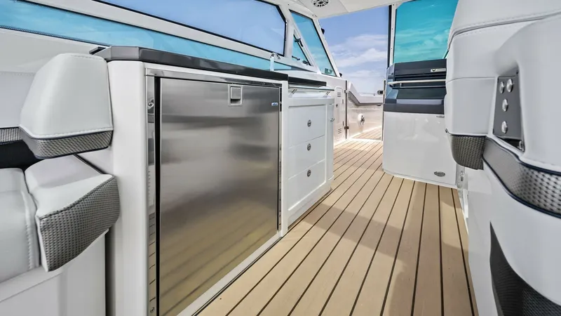 Slide: The Image of Cockpit Galley with Refrigerator The cockpit galley of the 2022 Formula 430 Super Sport Crossover features a sleek stainless steel refrigerator, perfect for keeping refreshments chilled. The elegant cabinetry and ample counter space provide functionality and style, while the teak floorin - 7030615