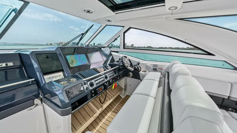 Slide: The Image of Helm Station with Panoramic Views The helm station of the 2022 Formula 430 Super Sport Crossover offers an advanced navigation experience with dual multifunction displays and intuitive controls. Plush, white seating provides comfort while large windows and a panoramic sunroof flood the ar - 7030610