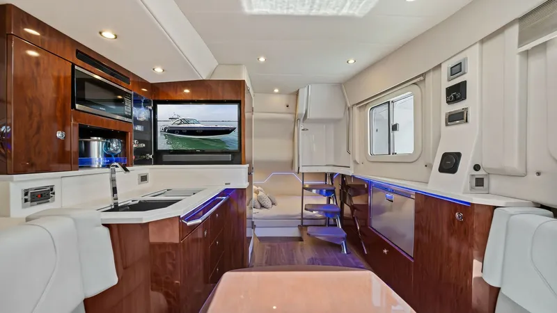 Slide: The Image of Interior Salon with Galley and Seating This inviting interior salon of the Blue Agave features a well-appointed galley with sleek cabinetry and modern appliances, ideal for onboard entertaining. The rich wood finishes and ambient lighting create a warm and sophisticated atmosphere. A comfortab - 7030590
