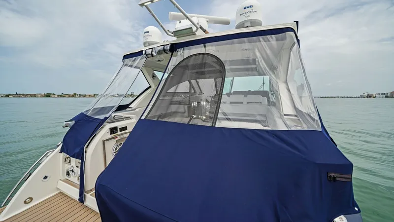 Slide: The Image of Aft Deck with Enclosure Covering The aft deck of the Blue Agave features a protective enclosure, providing shelter and privacy. The high-quality blue canvas cover ensures the area remains shielded from the elements, enhancing the vessel's durability. This space is ideal for entertaining, - 7030600
