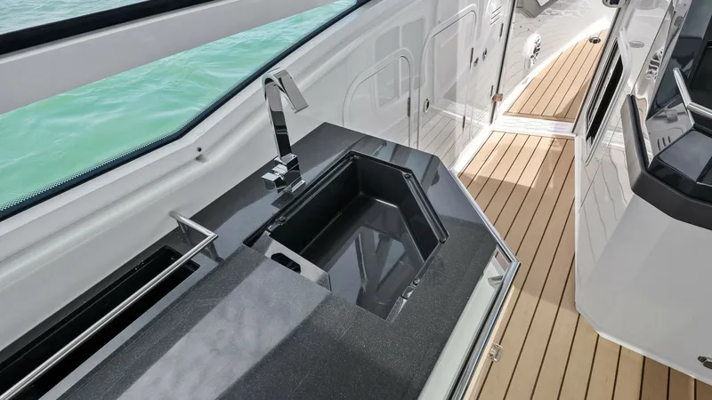Slide: The Image of Cockpit Wet Bar with Sink This image showcases the sleek cockpit wet bar area on the 2022 Formula 430 Super Sport Crossover. Featuring a modern black countertop with a built-in sink and stylish stainless-steel faucet, this space is designed for convenience and entertaining. The el - 7030616