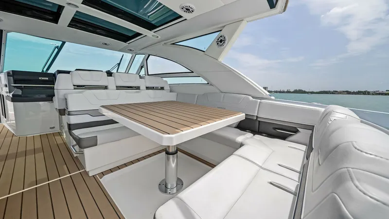 Slide: The Image of Spacious Cockpit Seating Area This inviting cockpit of the 2022 Formula 430 Super Sport Crossover features plush white seating and a stylish teak table, perfect for social gatherings. The open layout offers ample space and panoramic views, enhanced by the sleek overhead design with in - 7030604