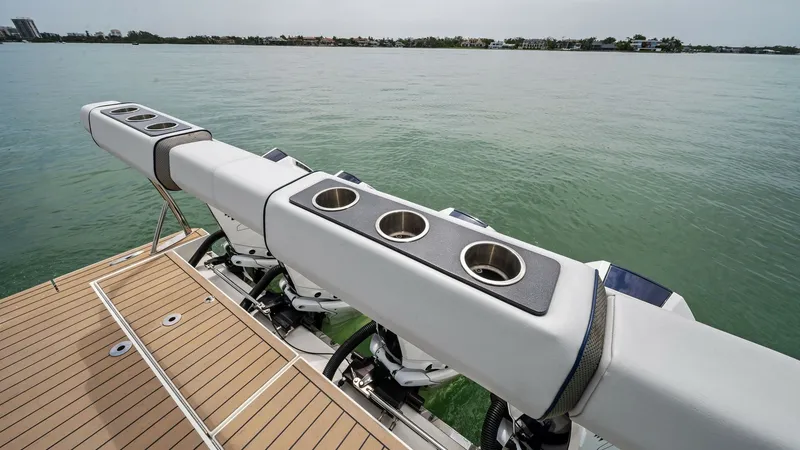 Slide: The Image of Aft Deck with Outboard Engines This image showcases the aft deck of the Blue Agave, featuring a sleek and spacious layout with multiple outboard engines. The teak decking adds a touch of elegance and durability, while the integrated rod holders make it ideal for fishing enthusiasts. Th - 7030594