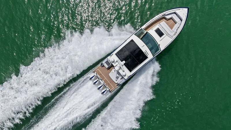 Slide: The Image of Aerial View of 430 Super Sport Crossover This dynamic aerial shot showcases the sleek design of the 2022 Formula 430 Super Sport Crossover, 'Blue Agave,' cutting through the water. The vessel's spacious deck layout is complemented by luxurious sun pads at the bow and a refined helm station. The - 7030637
