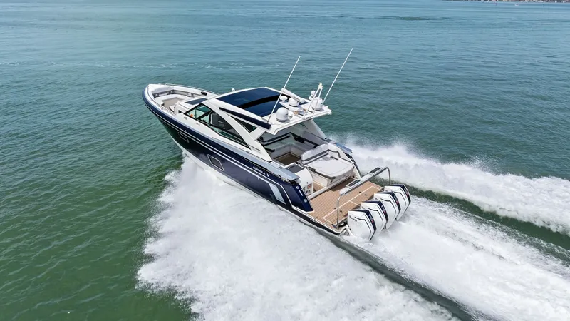 Slide: The Image of Aerial View of Stern and Engines This dynamic aerial shot showcases the powerful stern of the 2022 Formula 430 Super Sport Crossover, featuring four robust outboard engines. The spacious aft deck includes luxurious seating and a sleek swim platform, perfect for both relaxation and water - 7030638