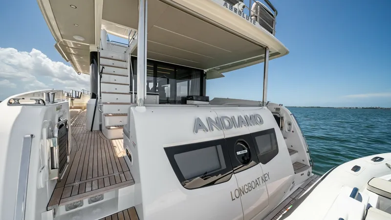 Slide: The Image of Stern Deck and Swim Platform The stern deck of the Absolute Navetta 58 features a spacious swim platform perfect for easy access to the water. The teak decking adds a touch of elegance, while the staircase leads up to the flybridge, offering a seamless flow between levels. This area - 7018657