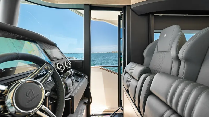Slide: The Image of Helm Station with Ocean View The helm station of the Absolute Navetta 58 offers a sleek, modern design with advanced navigation controls and luxurious leather seating. Expansive windows provide a panoramic view of the open sea, enhancing the captain's experience with natural light an - 7018645