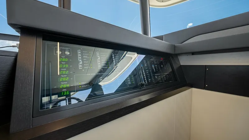 Slide: The Image of Modern Helm Station with Console The helm station of the 2026 Absolute Navetta 58 features a sleek, modern console with advanced digital instrumentation. The large display panels provide comprehensive navigation and system data, enhancing the captain's control and awareness. The design i - 7018642